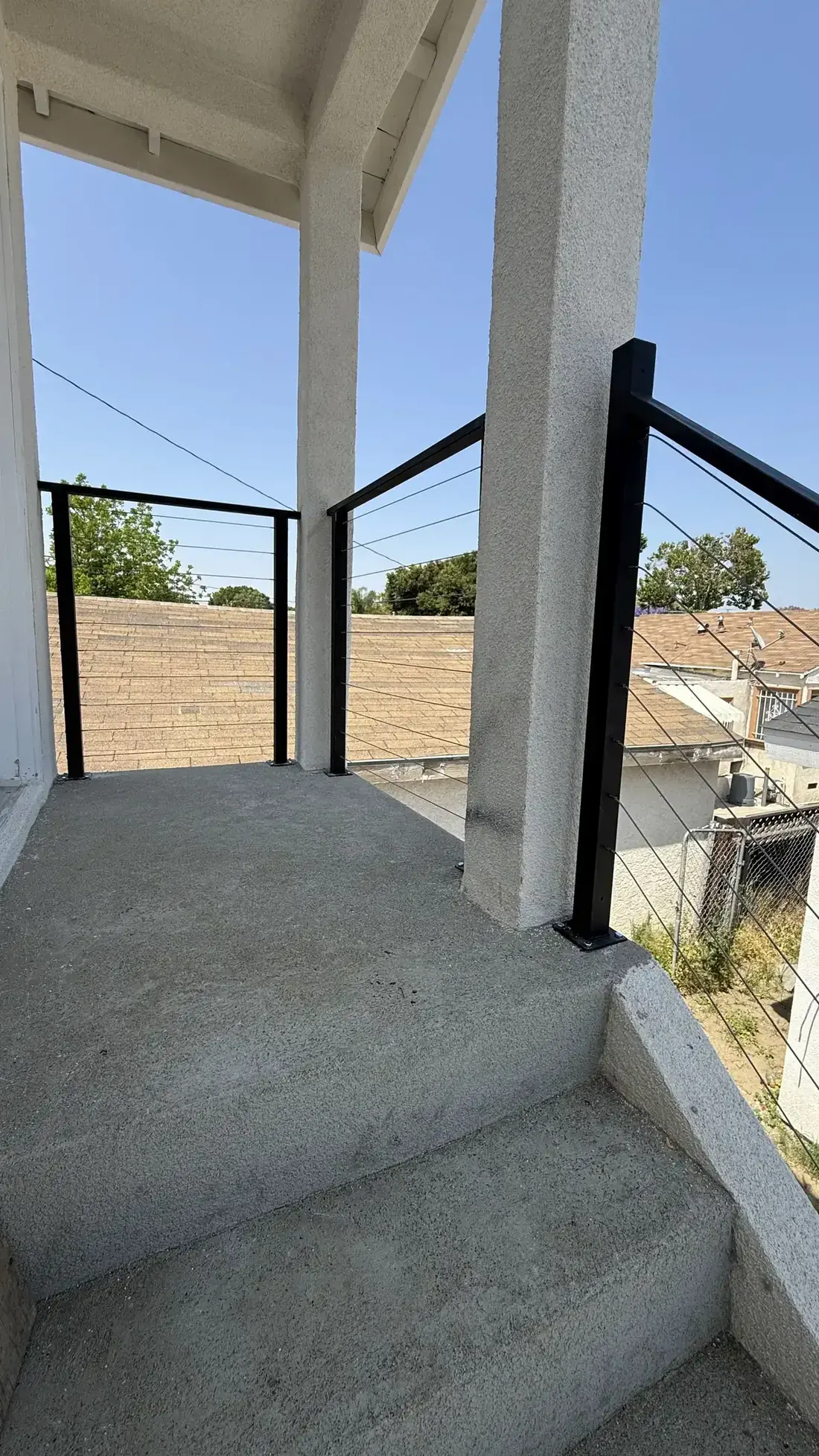 Black cable railing on a concrete porch landing