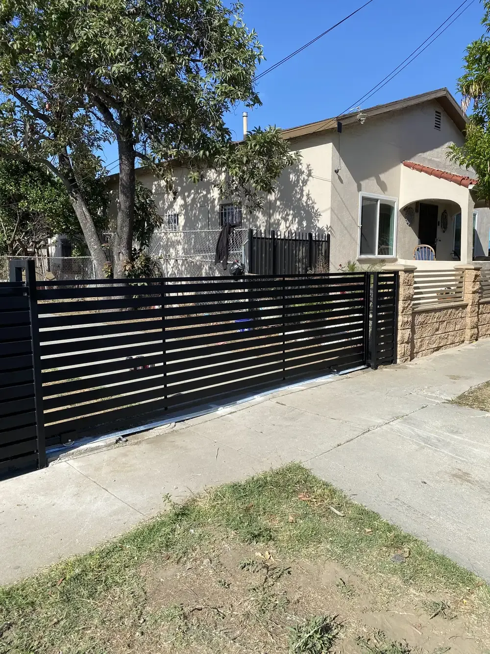 Black horizontal slat custom gate at a front yard